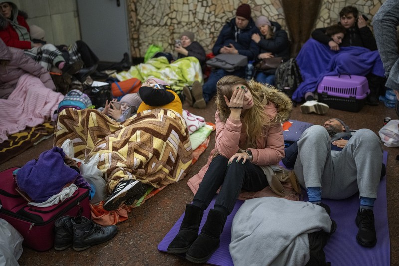 Warga Ukraina Mengungsi di parkir bawah tanah hotel Saat Invasi Rusia Seorang wanita tidur di kursi di tempat parkir bawah tanah hotel yang berubah menjadi tempat perlindungan bom selama serangan udara Rusia di Kyiv, Ukraina, Minggu (27/2/2022). Pria, wanita, dan anak-anak yang ketakutan mencari keselamatan di dalam dan di bawah tanah, dan pemerintah mempertahankan jam malam 39 jam untuk menjauhkan orang-orang dari jalanan karena lebih dari 150.000 orang Ukraina melarikan diri ke negara-negara tetangga dan PBB memperingatkan jumlah itu bisa bertambah menjadi 4 juta jika pertempuran meningkat. (AP Photo/Vadim Ghirda)