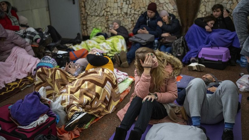 Seorang wanita tidur di kursi di tempat parkir bawah tanah hotel yang berubah menjadi tempat perlindungan bom selama serangan udara Rusia di Kyiv, Ukraina, Minggu (27/2/2022). Pria, wanita, dan anak-anak yang ketakutan mencari keselamatan di dalam dan di bawah tanah, dan pemerintah mempertahankan jam malam 39 jam untuk menjauhkan orang-orang dari jalanan karena lebih dari 150.000 orang Ukraina melarikan diri ke negara-negara tetangga dan PBB memperingatkan jumlah itu bisa bertambah menjadi 4 juta jika pertempuran meningkat. (AP Photo/Vadim Ghirda)