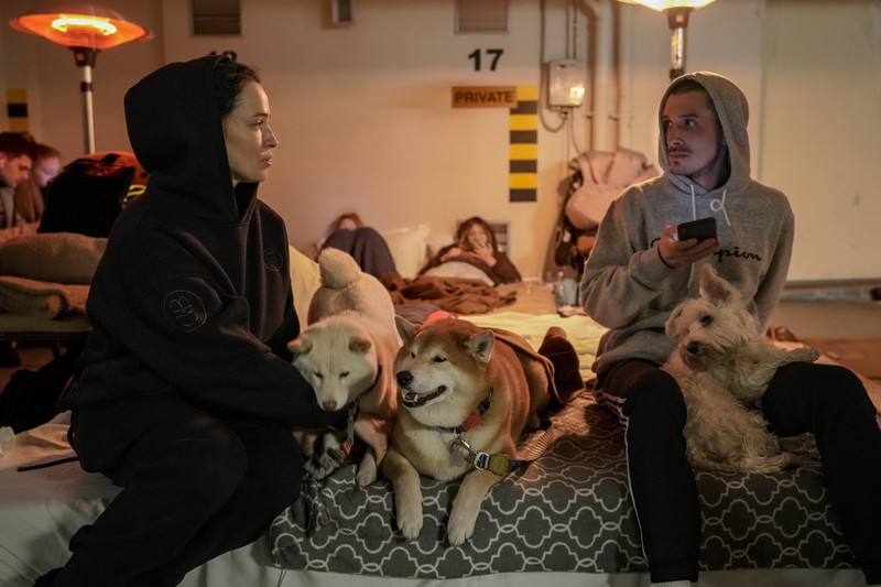 Warga Ukraina Mengungsi di parkir bawah tanah hotel Saat Invasi Rusia Seorang wanita tidur di kursi di tempat parkir bawah tanah hotel yang berubah menjadi tempat perlindungan bom selama serangan udara Rusia di Kyiv, Ukraina, Minggu (27/2/2022). Pria, wanita, dan anak-anak yang ketakutan mencari keselamatan di dalam dan di bawah tanah, dan pemerintah mempertahankan jam malam 39 jam untuk menjauhkan orang-orang dari jalanan karena lebih dari 150.000 orang Ukraina melarikan diri ke negara-negara tetangga dan PBB memperingatkan jumlah itu bisa bertambah menjadi 4 juta jika pertempuran meningkat. (AP Photo/Vadim Ghirda)