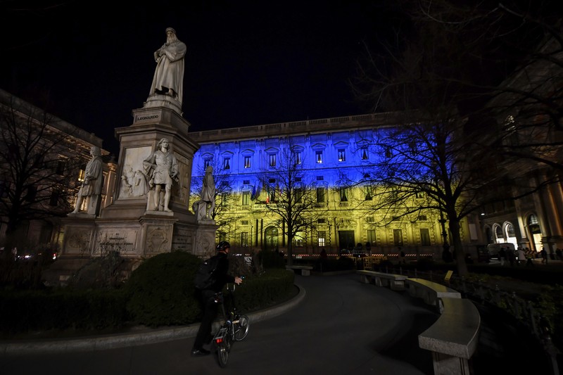 Gedung Opera berwarna bendera ukraina di Sydney, Australia Seorang pria berlari di sepanjang trotoar di seberang Gedung Opera yang diterangi dengan warna bendera nasional Ukraina sebagai dukungan solidaritas atas invasi Rusia di Sydney, Australia, Senin (28/2/2022). (AP Photo /Mark Baker)