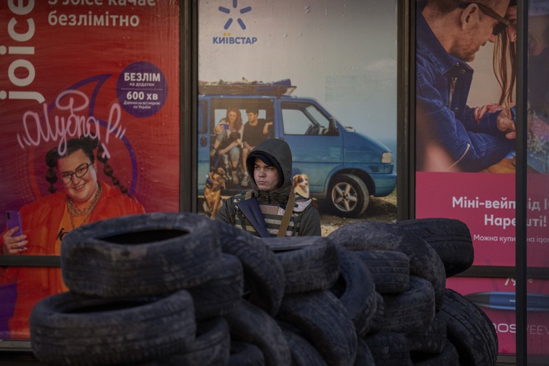 Anggota pertahanan sipil bersenjata berpose untuk foto saat berpatroli di jalan yang kosong karena jam malam di Kyiv, Ukraina,  Minggu (27/2/2022).  (AP Photo/Efrem Lukatsky)