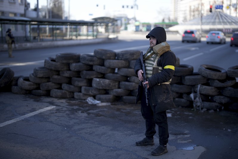 Pasukan Warga Sipil Ukraina Bersenjata Anggota pertahanan sipil bersenjata berpose untuk foto saat berpatroli di jalan yang kosong karena jam malam di Kyiv, Ukraina, Minggu (27/2/2022). (AP Photo/Efrem Lukatsky)