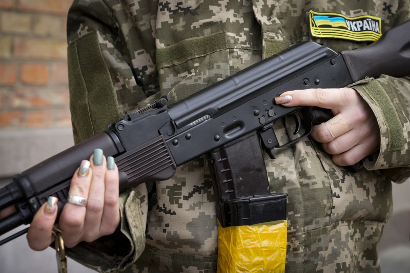 Pasukan Warga Sipil Ukraina Bersenjata Anggota pertahanan sipil bersenjata berpose untuk foto saat berpatroli di jalan yang kosong karena jam malam di Kyiv, Ukraina, Minggu (27/2/2022). (AP Photo/Efrem Lukatsky)