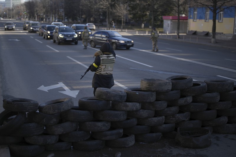 Anggota pertahanan sipil bersenjata berpose untuk foto saat berpatroli di jalan yang kosong karena jam malam di Kyiv, Ukraina,  Minggu (27/2/2022).  (AP Photo/Efrem Lukatsky)