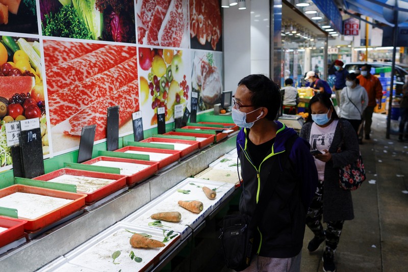 A customer wearing a mask buys fresh meat at a supermarket ahead of mass coronavirus disease (COVID-19) testing in Hong Kong, China March 1, 2022. REUTERS/Tyrone Siu