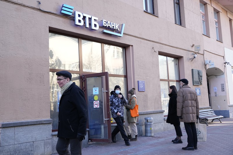 Russia Ukraine War Russia Economy People stand in line to withdraw U.S. dollars and Euros from an ATM in St. Petersburg, Russia, Friday, Feb. 25, 2022. Ordinary Russians faced the prospect of higher prices and crimped foreign travel as Western sanctions over the invasion of Ukraine sent the ruble plummeting, leading uneasy people to line up at banks and ATMs on Monday in a country that has seen more than one currency disaster in the post-Soviet era. (AP Photo/Dmitri Lovetsky)