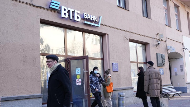 People stand in line to withdraw U.S. dollars and Euros from an ATM in St. Petersburg, Russia, Friday, Feb. 25, 2022. Ordinary Russians faced the prospect of higher prices and crimped foreign travel as Western sanctions over the invasion of Ukraine sent the ruble plummeting, leading uneasy people to line up at banks and ATMs on Monday in a country that has seen more than one currency disaster in the post-Soviet era. (AP Photo/Dmitri Lovetsky)
