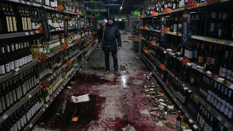 A member of the Ukrainian Territorial Defence Forces stands inside a supermarket, as Russia's invasion of Ukraine continues, in the town of Bucha in the Kyiv region, Ukraine February 28, 2022. REUTERS/Maksim Levin