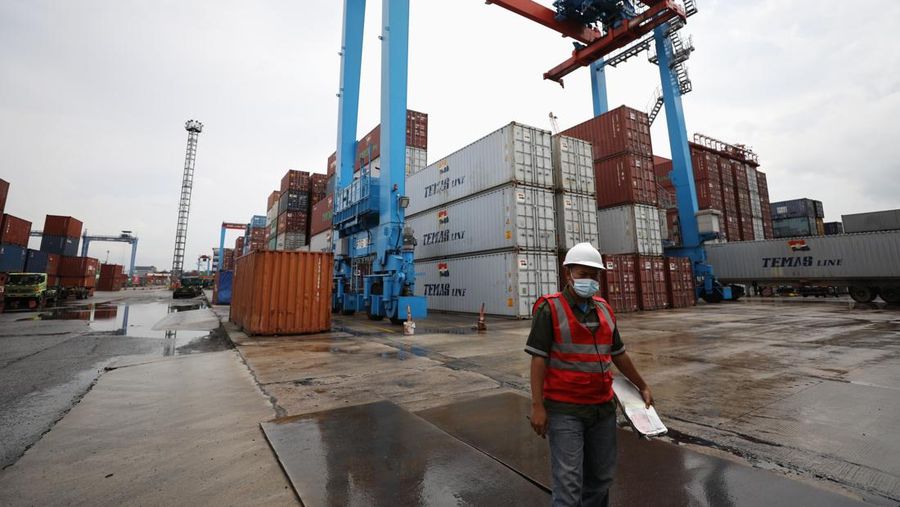 Pekerja melakukan aktivitas bongkar muat kontainer di pelabuhan Tanjung Priok, Jakarta, Jumat (4/3/2022). (CNBC Indonesia/Tri Susilo)
