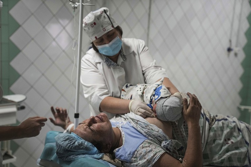 Russia Ukraine War Medical workers tend to women who gave birth in a basement of a maternity hospital converted into a medical ward and used as a bomb shelter in Mariupol, Ukraine, Tuesday, March 1, 2022. Russian strikes on the key southern port city of Mariupol seriously wounded several people. (AP Photo/Evgeniy Maloletka)