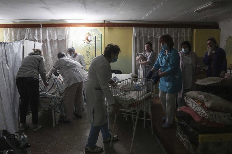 Medical workers tend to women who gave birth in a basement of a maternity hospital converted into a medical ward and used as a bomb shelter in Mariupol, Ukraine, Tuesday, March 1, 2022. Russian strikes on the key southern port city of Mariupol seriously wounded several people. (AP Photo/Evgeniy Maloletka)