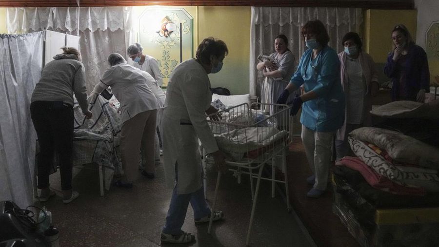 Medical workers tend to women who gave birth in a basement of a maternity hospital converted into a medical ward and used as a bomb shelter in Mariupol, Ukraine, Tuesday, March 1, 2022. Russian strikes on the key southern port city of Mariupol seriously wounded several people. (AP Photo/Evgeniy Maloletka)