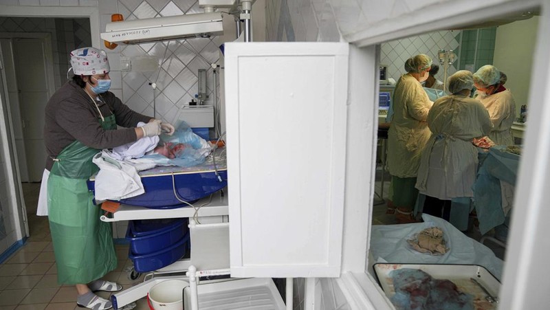 Medical workers tend to women who gave birth in a basement of a maternity hospital converted into a medical ward and used as a bomb shelter in Mariupol, Ukraine, Tuesday, March 1, 2022. Russian strikes on the key southern port city of Mariupol seriously wounded several people. (AP Photo/Evgeniy Maloletka)