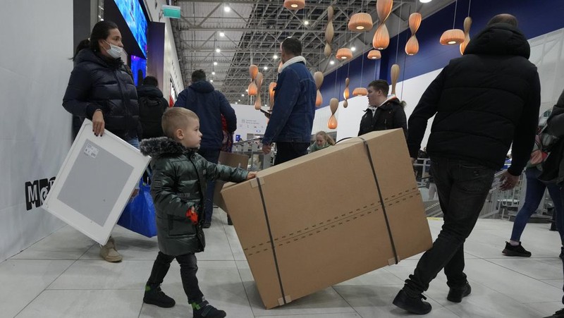 People wait in a line to enter the IKEA store at the outskirts of St. Petersburg, Russia, Thursday, March 3, 2022. IKEA is closing its stores and pausing all sourcing in Russia and Belarus from Friday, March 4. 