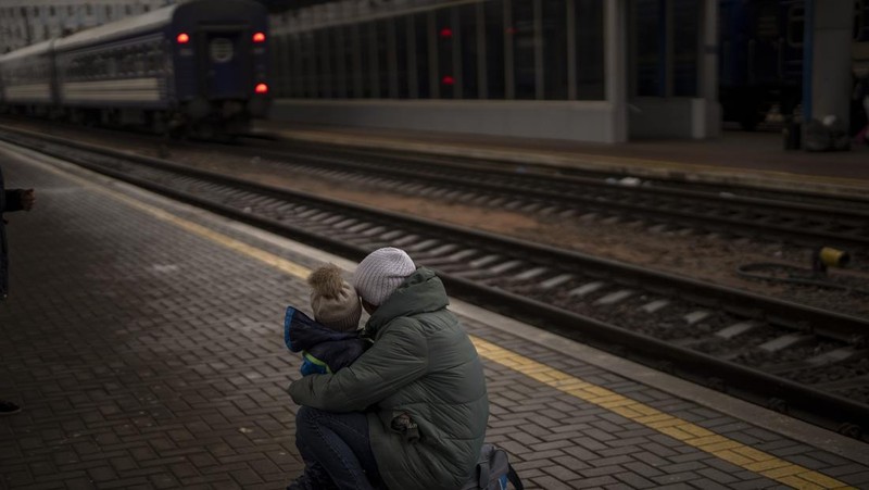 A couple says goodbye before she boards on a train bound for Lviv at the Kyiv station, Ukraine, Thursday, March 3. 2022. (AP Photo/Emilio Morenatti)