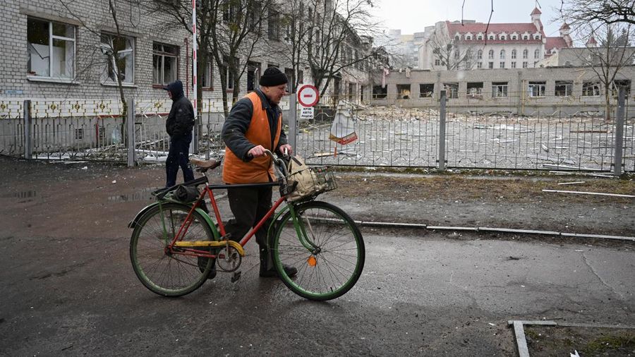 People walk near a school building destroyed by shelling, as Russia's invasion of Ukraine continues, in Zhytomyr, Ukraine March 4, 2022. REUTERS/Viacheslav Ratynskyi