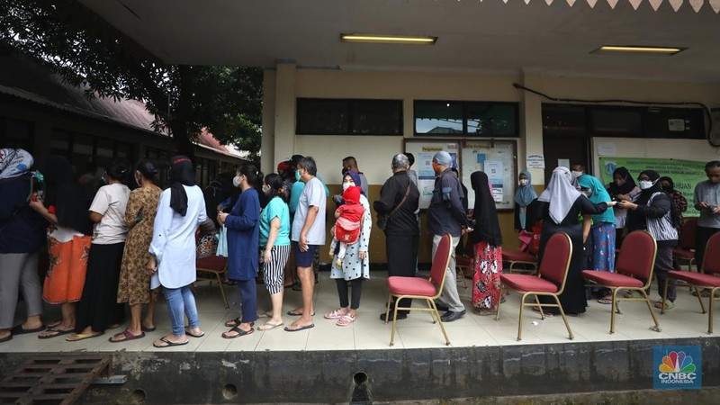 Warga antre untuk mendapatkan minyak goreng kemasan di GOR BRI, Radio Dalam, Jakarta, Senin (7/2/2022). Polsek Kebayoran Baru menggelar oprasi pasar minyak goreng murah mulai tanggal 7-9 Maret 2022. (CNBC Indonesia/ Tri Susilo)