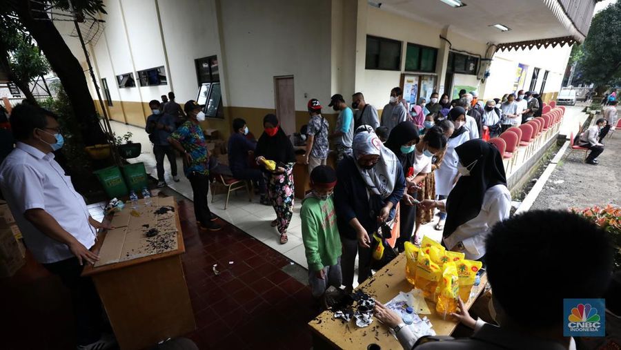 Warga antre untuk mendapatkan minyak goreng kemasan di GOR BRI, Radio Dalam, Jakarta, Senin (7/2/2022). Polsek Kebayoran Baru menggelar oprasi pasar minyak goreng murah mulai tanggal 7-9 Maret 2022. (CNBC Indonesia/ Tri Susilo)