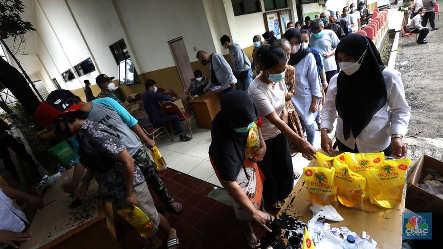 Warga antre untuk mendapatkan minyak goreng kemasan di GOR BRI, Radio Dalam, Jakarta, Senin (7/2/2022). Polsek Kebayoran Baru menggelar oprasi pasar minyak goreng murah mulai tanggal 7-9 Maret 2022. (CNBC Indonesia/ Tri Susilo)