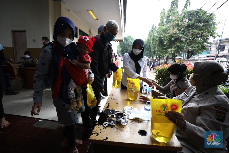Antrean pembelian Minyak Goreng Warga antre untuk mendapatkan minyak goreng kemasan di GOR BRI, Radio Dalam, Jakarta, Senin (7/2/2022). Polsek Kebayoran Baru menggelar oprasi pasar minyak goreng murah mulai tanggal 7-9 Maret 2022. (CNBC Indonesia/ Tri Susilo)