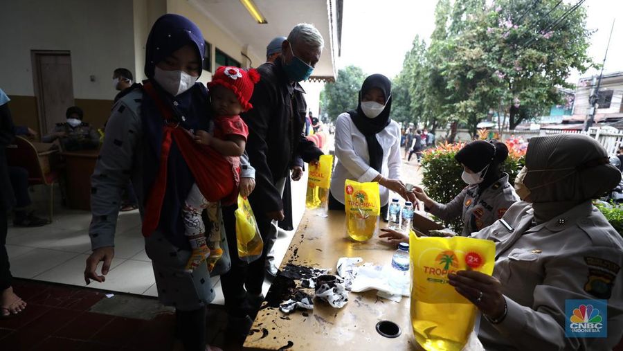 Warga antre untuk mendapatkan minyak goreng kemasan di GOR BRI, Radio Dalam, Jakarta, Senin (7/2/2022). Polsek Kebayoran Baru menggelar oprasi pasar minyak goreng murah mulai tanggal 7-9 Maret 2022. (CNBC Indonesia/ Tri Susilo)
