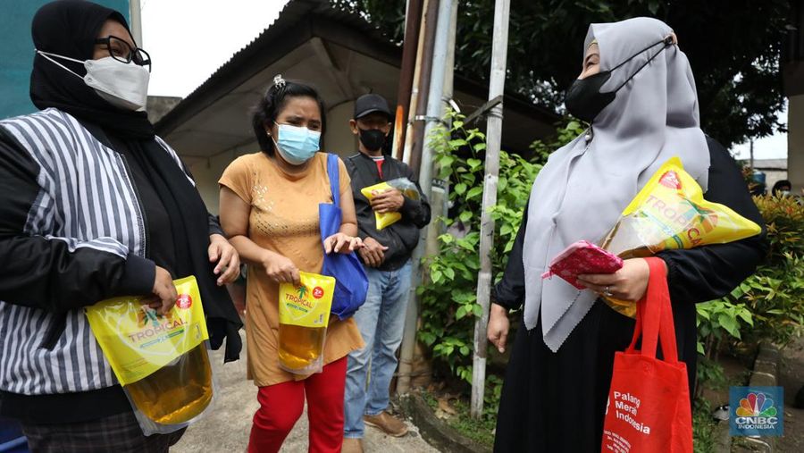 Warga antre untuk mendapatkan minyak goreng kemasan di GOR BRI, Radio Dalam, Jakarta, Senin (7/2/2022). Polsek Kebayoran Baru menggelar oprasi pasar minyak goreng murah mulai tanggal 7-9 Maret 2022. (CNBC Indonesia/ Tri Susilo)