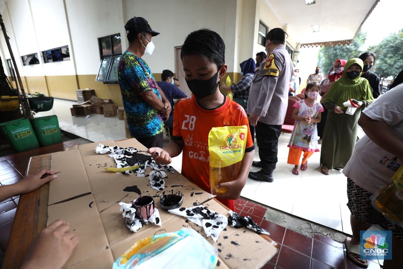 Antrean pembelian Minyak Goreng Warga antre untuk mendapatkan minyak goreng kemasan di GOR BRI, Radio Dalam, Jakarta, Senin (7/2/2022). Polsek Kebayoran Baru menggelar oprasi pasar minyak goreng murah mulai tanggal 7-9 Maret 2022. (CNBC Indonesia/ Tri Susilo)