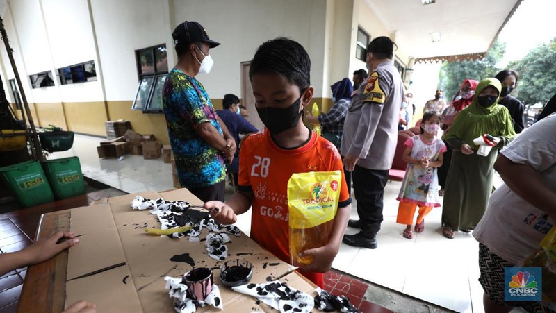 Warga antre untuk mendapatkan minyak goreng kemasan di GOR BRI, Radio Dalam, Jakarta, Senin (7/2/2022). Polsek Kebayoran Baru menggelar oprasi pasar minyak goreng murah mulai tanggal 7-9 Maret 2022. (CNBC Indonesia/ Tri Susilo)