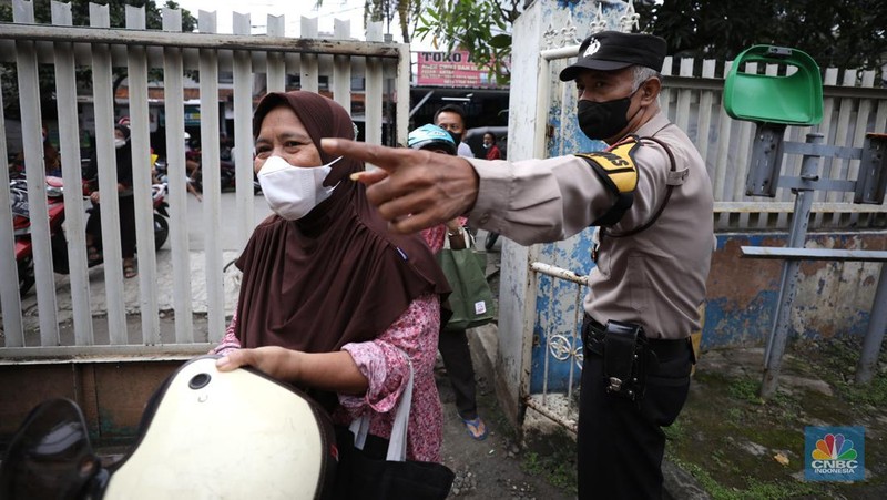 Warga antre untuk mendapatkan minyak goreng kemasan di GOR BRI, Radio Dalam, Jakarta, Senin (7/2/2022). Polsek Kebayoran Baru menggelar oprasi pasar minyak goreng murah mulai tanggal 7-9 Maret 2022. (CNBC Indonesia/ Tri Susilo)