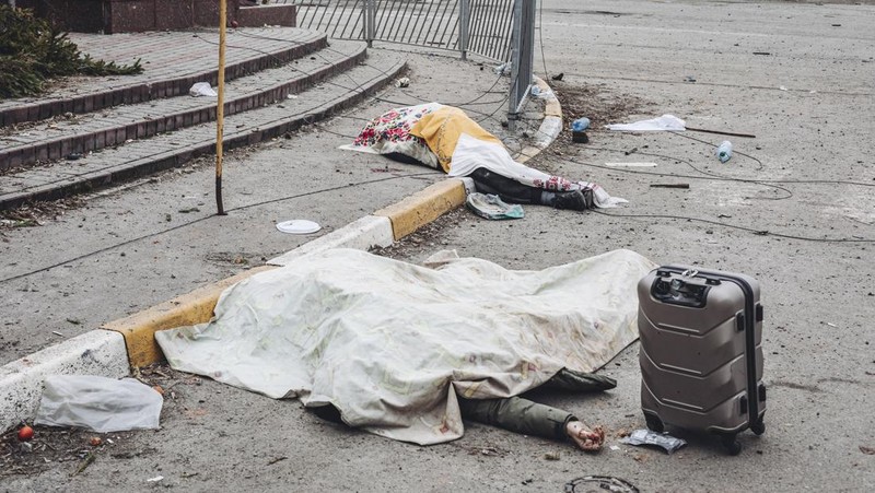 Prajurit Ukraina mencoba membantu orang-orang yang terluka akibat serangan militer Rusia di kota Irpin, Ukraina, Minggu (6/3/2022). (AP Photo/Andriy Dubchak)