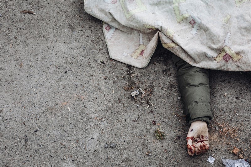 Prajurit Ukraina mencoba membantu orang-orang yang terluka akibat serangan militer Rusia di kota Irpin, Ukraina, Minggu (6/3/2022). (AP Photo/Andriy Dubchak)