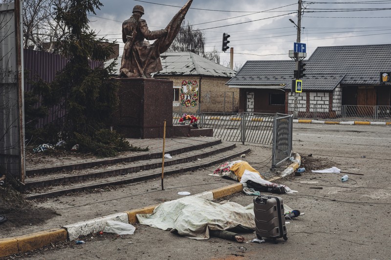 Prajurit Ukraina mencoba membantu orang-orang yang terluka akibat serangan militer Rusia di kota Irpin, Ukraina, Minggu (6/3/2022). (AP Photo/Andriy Dubchak)