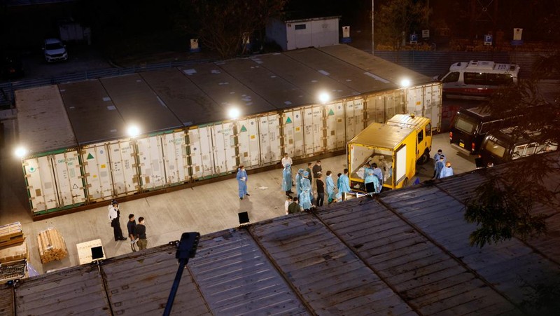 Petugas memindahkan  jenazah ke dalam kontainer berpendingin ksaat kamar jenazah kehabisan ruang di tengah wabah penyakit coronavirus (COVID-19)di Hong Kong, Sabtu (5/3/2022). (REUTERS/Tyrone Siu)