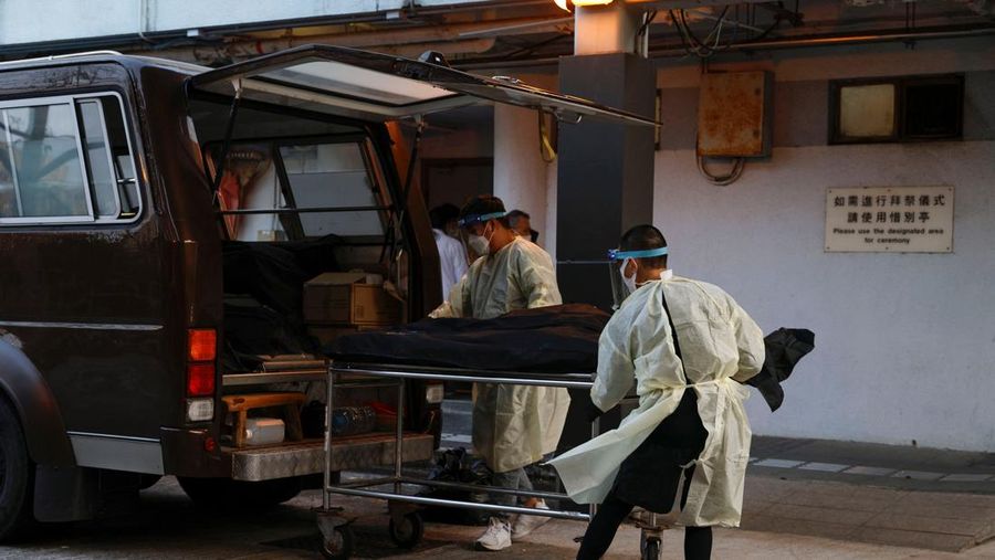 Pekerja memindahkan jenazah di kamar mayat, menyusul wabah penyakit virus corona (COVID-19) di Hong Kong, Sabtu (5/3/2022). (REUTERS/Tyrone Siu)