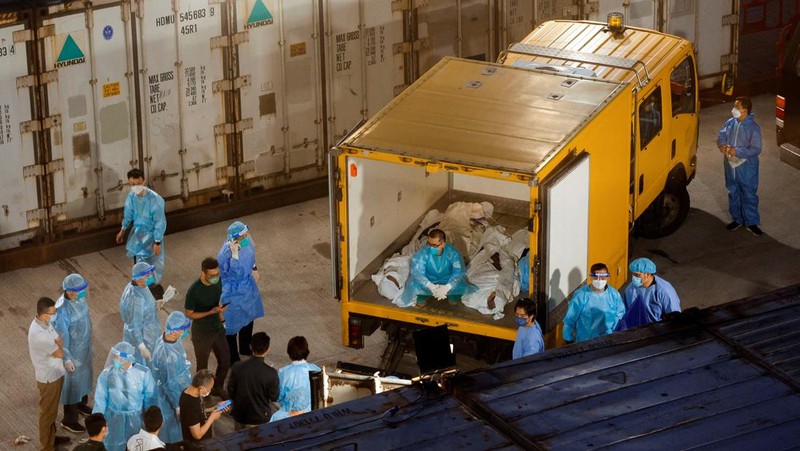 Petugas memindahkan  jenazah ke dalam kontainer berpendingin ksaat kamar jenazah kehabisan ruang di tengah wabah penyakit coronavirus (COVID-19)di Hong Kong, Sabtu (5/3/2022). (REUTERS/Tyrone Siu)