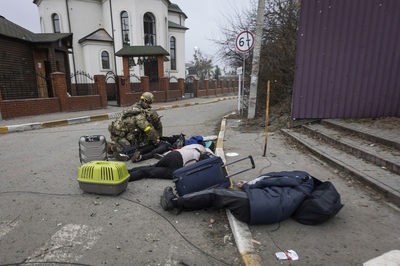 Korban Terluka Warga Ukraina Akibat Serangan Rusia Prajurit Ukraina mencoba membantu orang-orang yang terluka akibat serangan militer Rusia di kota Irpin, Ukraina, Minggu (6/3/2022). (AP Photo/Andriy Dubchak)