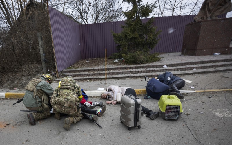 Korban Terluka Warga Ukraina Akibat Serangan Rusia Prajurit Ukraina mencoba membantu orang-orang yang terluka akibat serangan militer Rusia di kota Irpin, Ukraina, Minggu (6/3/2022). (AP Photo/Andriy Dubchak)