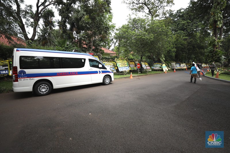 Warga melewati karangan bunga ucapan duka cita di halaman rumah duka almarhum Arifin Panigoro di Griya Jenggala, Jakarta, Senin (7/3/2022). Anggota Dewan Pertimbangan Presiden (Wantimpres) Arifin Panigoro meninggal dunia di Amerika Serikat pada Minggu (6/3/2022). Menurut penjaga keamanan setempat 