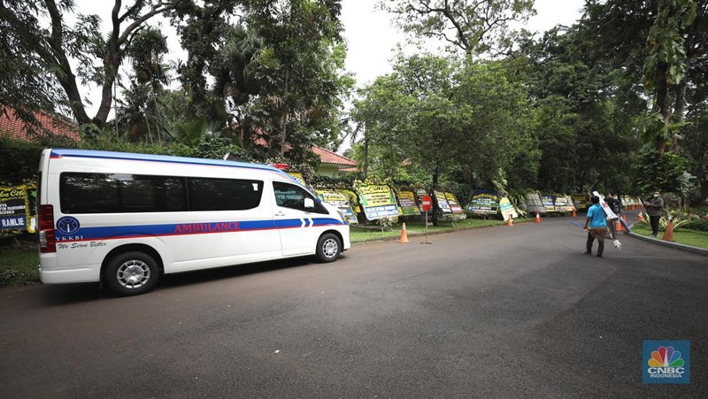 Warga melewati karangan bunga ucapan duka cita di halaman rumah duka almarhum Arifin Panigoro di Griya Jenggala, Jakarta, Senin (7/3/2022). Anggota Dewan Pertimbangan Presiden (Wantimpres) Arifin Panigoro meninggal dunia di Amerika Serikat pada Minggu (6/3/2022). Menurut penjaga keamanan setempat 
