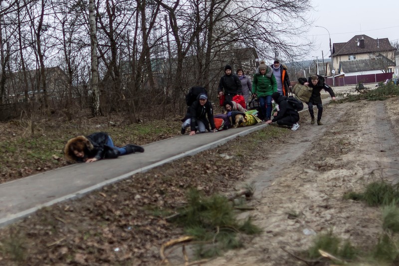 Warga Ukraina melarikan diri untuk evakuasi saat terjadi penyerangan oleh Rusia Warga melintasi jalan setapak di bawah jembatan yang hancur saat melarikan diri dari kota Irpin, Ukraina, MInggu (6/3/2022). Di Irpin, dekat Kyiv, ratusan warga berjalan kaki dan bahkan dengan gerobak dorong melewati sisa-sisa jembatan yang hancur untuk menyeberangi sungai dan meninggalkan kota. (AP Photo/Oleksandr Ratushniak)