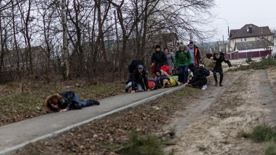Warga melintasi jalan setapak di bawah jembatan yang hancur saat melarikan diri dari kota Irpin, Ukraina, MInggu (6/3/2022).  Di Irpin, dekat Kyiv, ratusan warga berjalan kaki dan bahkan dengan gerobak dorong melewati sisa-sisa jembatan yang hancur untuk menyeberangi sungai dan meninggalkan kota. (AP Photo/Oleksandr Ratushniak)