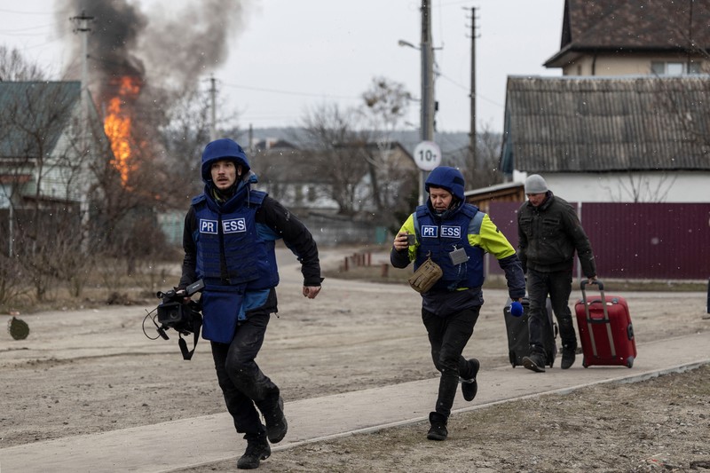 Warga Ukraina melarikan diri untuk evakuasi saat terjadi penyerangan oleh Rusia Warga melintasi jalan setapak di bawah jembatan yang hancur saat melarikan diri dari kota Irpin, Ukraina, MInggu (6/3/2022). Di Irpin, dekat Kyiv, ratusan warga berjalan kaki dan bahkan dengan gerobak dorong melewati sisa-sisa jembatan yang hancur untuk menyeberangi sungai dan meninggalkan kota. (AP Photo/Oleksandr Ratushniak)
