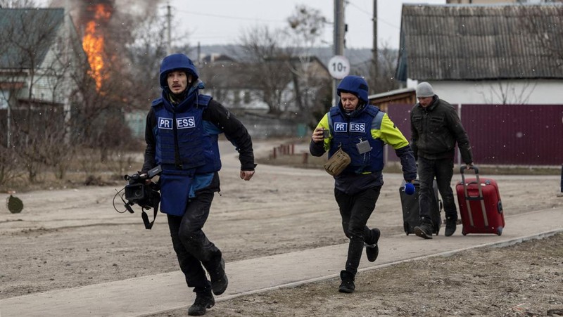 Warga melintasi jalan setapak di bawah jembatan yang hancur saat melarikan diri dari kota Irpin, Ukraina, MInggu (6/3/2022).  Di Irpin, dekat Kyiv, ratusan warga berjalan kaki dan bahkan dengan gerobak dorong melewati sisa-sisa jembatan yang hancur untuk menyeberangi sungai dan meninggalkan kota. (AP Photo/Oleksandr Ratushniak)
