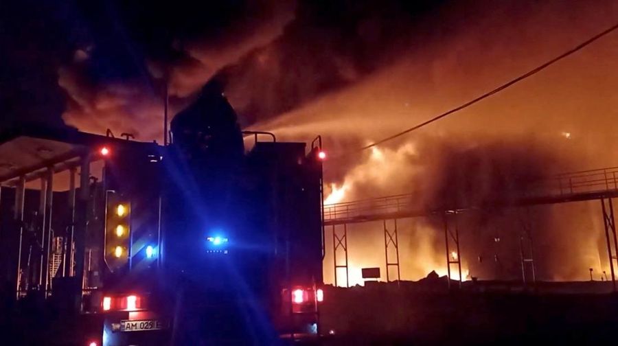 Petugas pemadam kebakaran memadamkan api di depot minyak yang menurut Layanan Darurat Negara Ukraina disebabkan oleh serangan Rusia di wilayah Zhytomyr, Ukraina, Senin (7/3/2022). (Tangkapan layar video State Emergency Services of Ukraine/Handout via REUTERS)