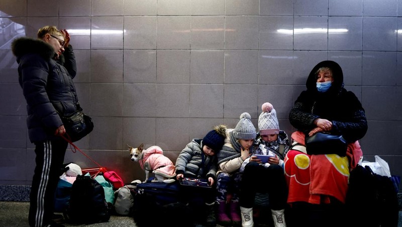 Relawan membagikan makanan kepada orang-orang yang melintasi perbatasan dari Ukraina ke Polandia, setelah melarikan diri dari iserangan Rusia ke Ukraina, di pos pemeriksaan perbatasan di Medyka, Polandia, Selasa (8/3/2022). (REUTERS/Fabrizio Bensch)