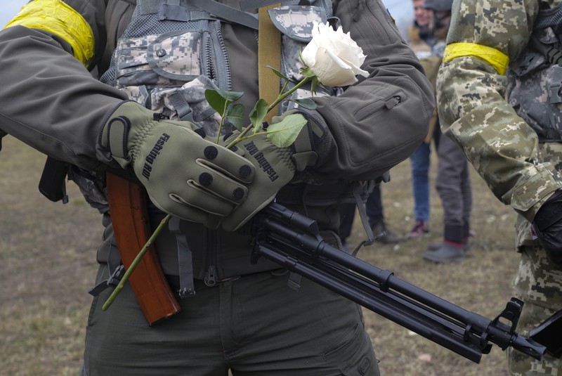 Pernikahan Militer Ukraina Anggota Pasukan Pertahanan Teritorial Ukraina Lesia Ivashchenko dan Valerii Fylymonov mendengarkan seorang pendeta di pernikahan mereka selama konflik Ukraina-Rusia, di sebuah pos pemeriksaan di Kyiv, Ukraina, Minggu (6/3/2022). (REUTERS/Mykola Tymchenko)