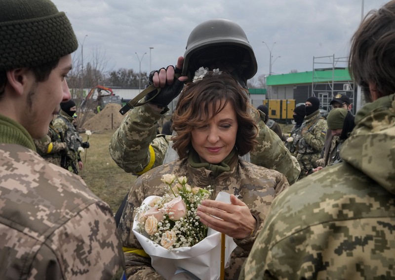 Pernikahan Militer Ukraina Anggota Pasukan Pertahanan Teritorial Ukraina Lesia Ivashchenko dan Valerii Fylymonov mendengarkan seorang pendeta di pernikahan mereka selama konflik Ukraina-Rusia, di sebuah pos pemeriksaan di Kyiv, Ukraina, Minggu (6/3/2022). (REUTERS/Mykola Tymchenko)
