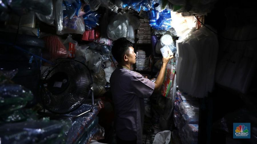 Pedagang melayani pembeli kantong plastik di Pasar Jaya Slipi, Jakarta, Rabu (9/3/2022). Lonjakan harga minyak mentah mendongkrak kenaikan harga bahan baku plastik. Baik untuk jenis Low Density Polyethylene (LDPE), Linear Low Density Polyethylene (LLDPE), High Density Polyethylene (HDPE), maupun Polypropylene (PP). (CNBC Indonesia/ Tri Susilo)