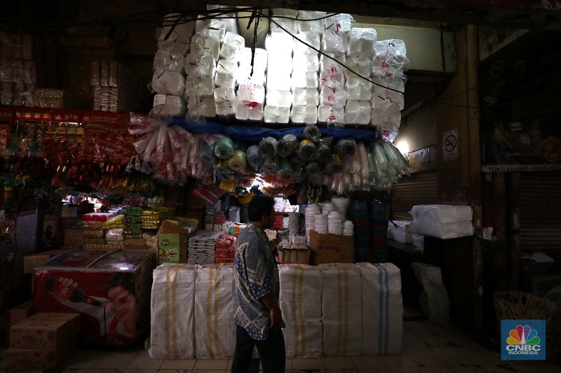 Pedagang melayani pembeli kantong plastik di Pasar Jaya Slipi, Jakarta, Rabu (9/3/2022). Lonjakan harga minyak mentah mendongkrak kenaikan harga bahan baku plastik. Baik untuk jenis Low Density Polyethylene (LDPE), Linear Low Density Polyethylene (LLDPE), High Density Polyethylene (HDPE), maupun Polypropylene (PP). (CNBC Indonesia/ Tri Susilo)