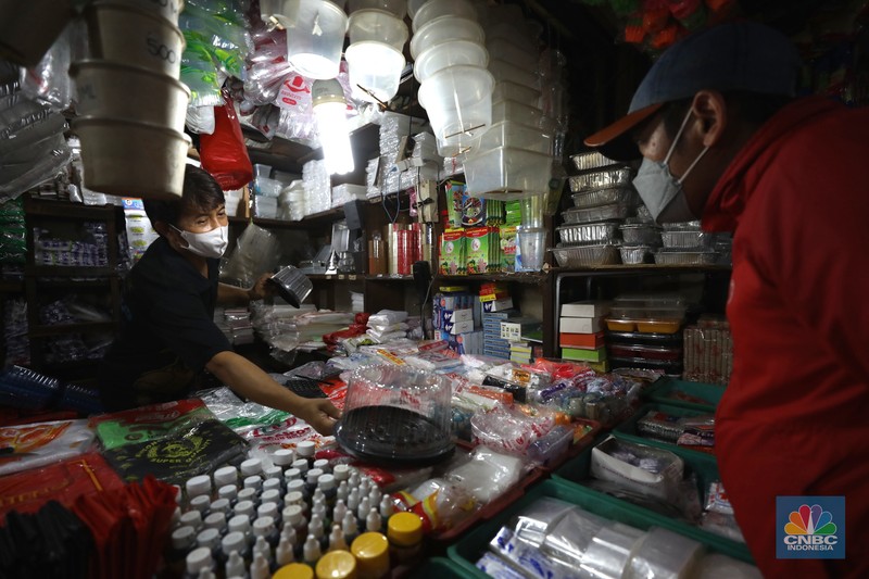 Pedagang melayani pembeli kantong plastik di Pasar Jaya Slipi, Jakarta, Rabu (9/3/2022). Lonjakan harga minyak mentah mendongkrak kenaikan harga bahan baku plastik. Baik untuk jenis Low Density Polyethylene (LDPE), Linear Low Density Polyethylene (LLDPE), High Density Polyethylene (HDPE), maupun Polypropylene (PP). (CNBC Indonesia/ Tri Susilo)